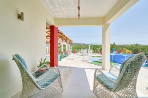 weranda z 2 krzesłami i basenem w obiekcie Red House on the beach w mieście Punta Rucia