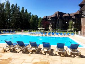 a group of chairs and a swimming pool at Appartement 1 Chambre 4 Pers - Piscine Chauffé - Parking Gratuit - Vue Golf Deauville - La Deauvillaise Résidence du Golf in Deauville +75 photos