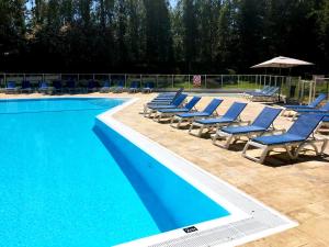 um grupo de espreguiçadeiras e uma piscina em La Deauvillaise - Résidence du Golf em Deauville