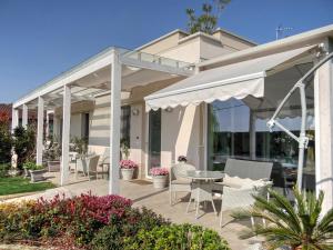 un patio avec des chaises et une table sous un pavillon dans l'établissement B&B La Magia dei Sogni Relais, à Vérone