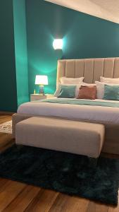 uma cama grande num quarto com uma parede azul em Résidence Gabrielle em São Tomé