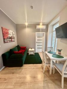 uma sala de estar com um sofá verde e uma mesa em Apartment Targowa L9 em Lublin