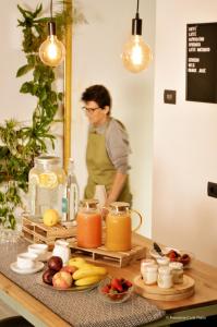 un homme debout devant une table avec des fruits et des jus dans l'établissement Foresteria Cà di Nadin, à Carriola