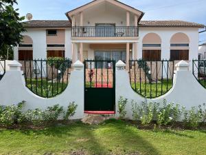 una casa con una puerta verde y una valla en Résidence Gabrielle, en São Tomé