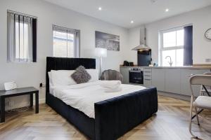 a bedroom with a large bed and a kitchen at Wimbourne Road Apartment 1 in Bournemouth