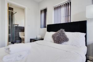 a white bed with a black headboard and white pillows at Wimbourne Road Apartment 1 in Bournemouth