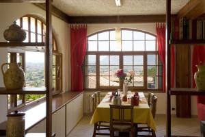 una sala da pranzo con tavolo e una grande finestra di Casa Vacanze Colline di Luni a Castelnuovo di Magra