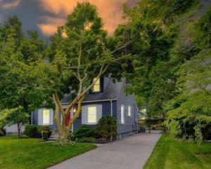 a blue house with a tree in front of it at Vibrant and Spacious 4bd Home 5 Mins to DT Royal Oak in Royal Oak