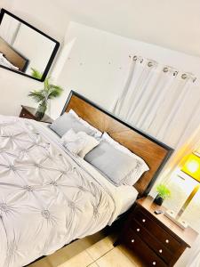 um quarto com uma cama branca e uma cabeceira em madeira em Perfect relaxing 12 mn from the Beach free parking em West Palm Beach