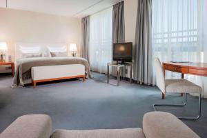 a hotel room with a bed and a television at Dorint Pallas Wiesbaden in Wiesbaden