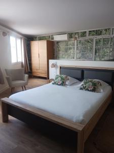 - une chambre avec un grand lit et une chaise dans l'établissement Cotinga, à Villars-les-Dombes