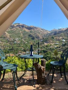 ベガ・デ・サン・マテオにあるAngel Caves Farmstayのテーブルと椅子、ワイン1本