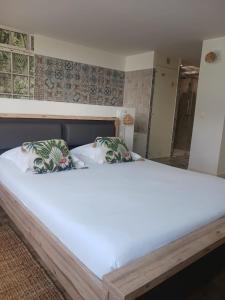 - un grand lit avec 2 oreillers dans l'établissement Cotinga, à Villars-les-Dombes