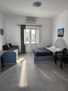 a bedroom with two beds and a couch at Mary Rooms in Perivolos