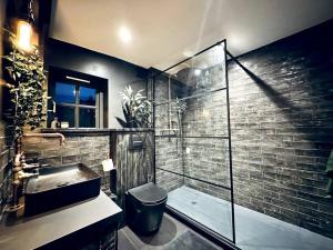 a bathroom with a sink and a glass shower at Cotswold Garden Cottage in Chipping Norton