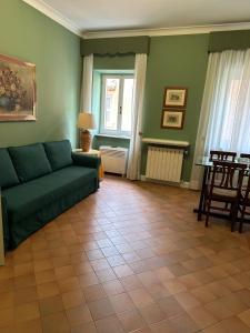 a living room with a green couch and a table at Relais Rasella 47 in Rome