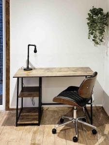 a desk with a chair and a lamp on it at Cotswold Garden Cottage in Chipping Norton