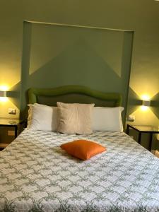 ein Bett mit orangefarbenem Kissen darüber in der Unterkunft Relais Rasella 47 in Rom