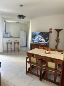 cocina y sala de estar con mesa y TV en Apartamento Copacabana sistema Apart-hotel, en Río de Janeiro