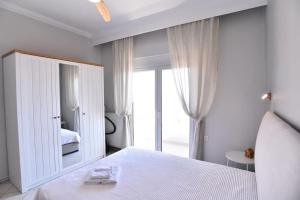 a bedroom with a white bed and a large mirror at Blue Memories in Kavala