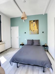 een slaapkamer met een groot bed met blauwe muren bij La Licorne, grand studio chaleureux in Amiens
