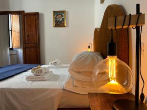 a bedroom with a bed with towels and a lamp at Vitozzi Suite in Orvieto