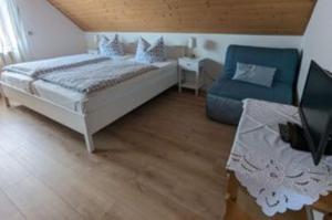 a bedroom with a bed and a blue chair at Ferienwohnung zum Wohlfühlen in Altensteig