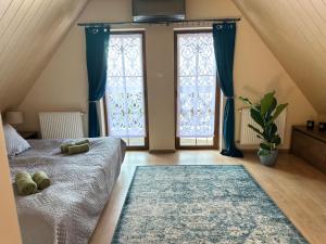 ein Schlafzimmer mit einem Bett und zwei großen Fenstern in der Unterkunft Piękna Góra in Giżycko