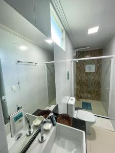 a bathroom with a sink and a toilet and a mirror at Estrela Premium Pousada in Gamboa +20 photos