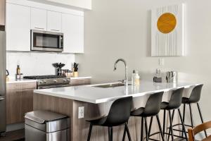 a kitchen with a large white island with bar stools at New! Sprawling Floor Plan - Central LoHi - Peloton in Denver