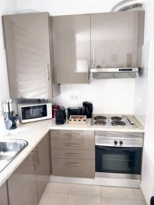 una cocina con estufa y microondas en Cozy studio in Quinta do Anjo 48 m² with shared sauna, en Quinta do Anjo