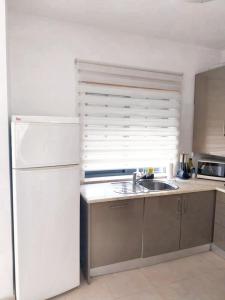 Una cocina con un refrigerador blanco y un fregadero. en Cozy studio in Quinta do Anjo 48 m² with shared sauna, en Quinta do Anjo 7 fotos más
