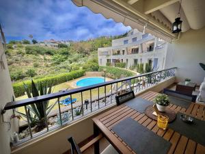 uma varanda com uma mesa e vista para uma piscina em Marbella Los Monteros with Pool by Homing em Marbella