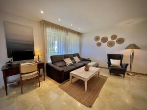 uma sala de estar com um sofá e uma mesa em Marbella Los Monteros with Pool by Homing em Marbella