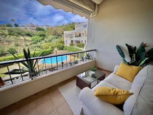 uma sala de estar com um sofá e uma varanda com uma piscina em Marbella Los Monteros with Pool by Homing em Marbella