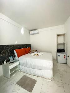 a bedroom with a large bed and a small refrigerator at Estrela Premium Pousada in Gamboa
