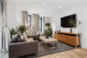 uma sala de estar com um sofá e uma televisão de ecrã plano em 2 Bedroom flat near shops and restaurants em Londres