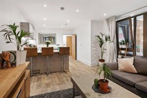 uma sala de estar com um sofá e uma cozinha em 2 Bedroom flat near shops and restaurants em Londres