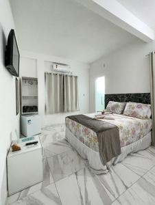 sypialnia z dużym łóżkiem i telewizorem w obiekcie Estrela Premium Pousada w mieście Gamboa