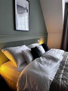 a bed with pillows on it in a bedroom at Apartments by Prague City Golf in Prague
