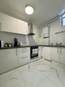 a large white kitchen with white cabinets and appliances at Magnifique appart côté Cathédrale in Strasbourg