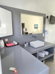 a bathroom with a sink and a mirror at Mary Rooms in Perivolos