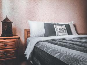 1 dormitorio con cama y mesita de noche de madera en Tayafut ApartmentTerrace, en Mirleft