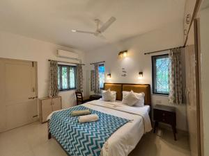 een slaapkamer met een groot bed met een blauwe en witte deken bij Quintara Serviced Apartments in North Goa in Porvorim