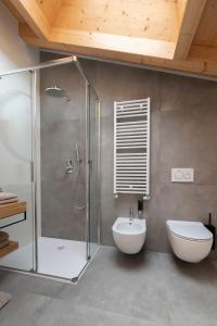 a bathroom with a shower and a toilet and a sink at ARPA DI PIETRA - Luxury B&B SPA BIO - Adults Only in Mori +24 photos