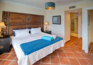a bedroom with a large bed with a wooden headboard at La Perla De La Bahia in Bahia de Casares +14 photos