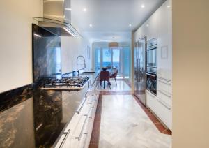 a kitchen with white counters and a large island with a stove at La Perla De La Bahia in Bahia de Casares