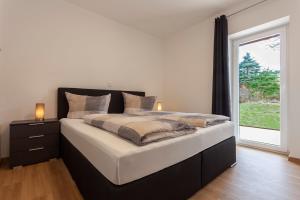 1 dormitorio con 1 cama grande y ventana en Ferienwohnung 8, en Lechbruck