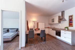 een keuken en een woonkamer met een tafel en stoelen bij Ferienwohnung 25 in Lechbruck