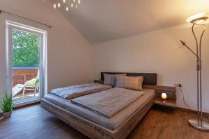 a bedroom with a bed and a large window at Ferienwohnung 25 in Lechbruck